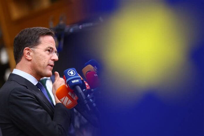 Mark Rutte, secretarul general NATO, vorbeste la microfoane in cadrul unui summit european. Profil din stanga, costum inchis, cravata verde. Microfoane WDR si alte posturi media vizibile. Fundal albas mark rutte conferinta nato sprijin ucraina cheltuieli aparare aliati