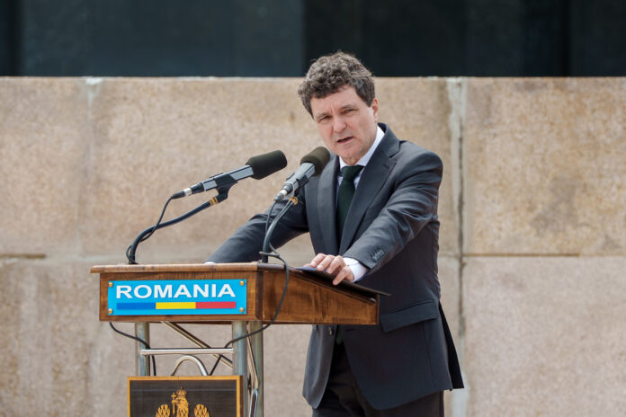 Nicușor Dan la pupitru exterior cu inscripția 'ROMANIA', discurs în aer liber, cadru solemn nicusor dan consultari cotroceni parlamentari dialog politic stabilitate